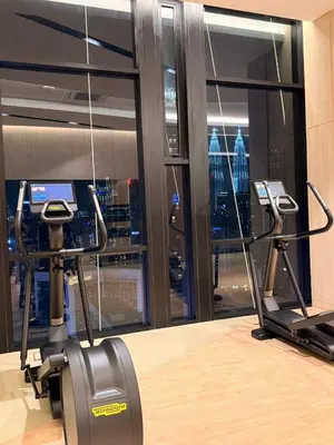a gym with a view of the empire state building at Axon KL Infinity Pool Suites near Pavilion in Kuala Lumpur