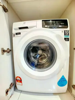 a white washing machine sitting in a room at Chambers Residence Specious Suites KlCC in Kuala Lumpur