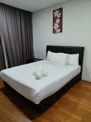 a bedroom with a large bed with white sheets at Vortex Suite Klcc By Sky Moon in Kuala Lumpur