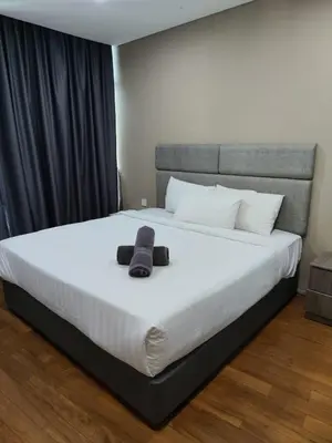 a bed with a teddy bear sitting on top of it at Vortex Suite Klcc By Sky Moon in Kuala Lumpur