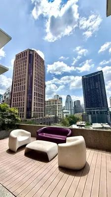 twoools and seats on a deck with a city skyline at Kuala Lumpur Quill Residences By AR Stay in Kuala Lumpur
