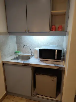 a kitchen counter with a microwave and a sink at Moonlight Apartment service at Times Square kl in Kuala Lumpur