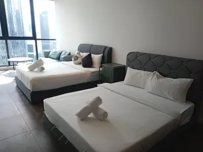 a hotel room with two beds and a couch at Scarletz suites Klcc by Sunlight in Kuala Lumpur