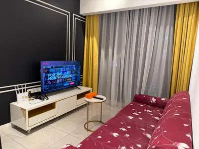 a living room with a couch and a flat screen tv at Infinity pool luxury Apartment Axon in Kuala Lumpur