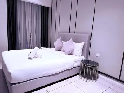 a bedroom with a large bed with white sheets and pillows at Infinity pool luxury Apartment Axon in Kuala Lumpur