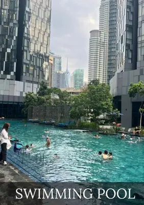 people swimming in a swimming pool in a city at Metro Star KLCC Living in Kuala Lumpur