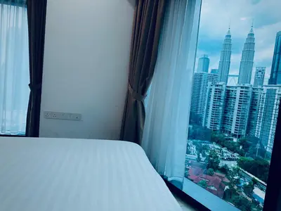a bedroom with a window with a view of a city at Eaton Residences By Tropika KLCC in Kuala Lumpur