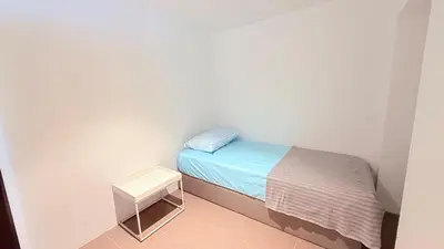 a small bedroom with a bed and a small table at Relax and cozy, entire unit in Kuala Lumpur