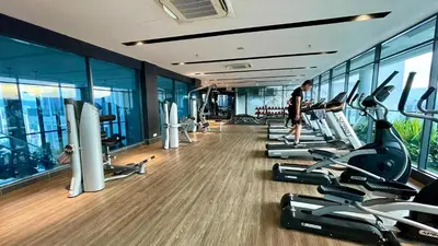 a man walking through a gym with cardio machines at Majestic Premium Residence Suites KLCC by Alaman in Kuala Lumpur