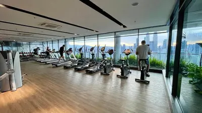 a gym with people exercising on treadmills in a building at Majestic Premium Residence Suites KLCC by Alaman in Kuala Lumpur
