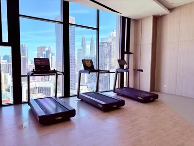 a gym with three elliptical machines in front of a window at Luxury Dream Home At Axon Residence Bukit Bintang Klcc pavilion in Kuala Lumpur