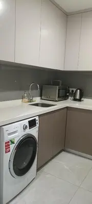 a kitchen with a washing machine and a sink at Elite Suites at Agile Bukit Bintang Kuala Lumpur in Kuala Lumpur