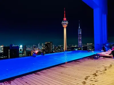 a rooftop pool with a view of the city at night at The Grand klcc at platinum face in Kuala Lumpur