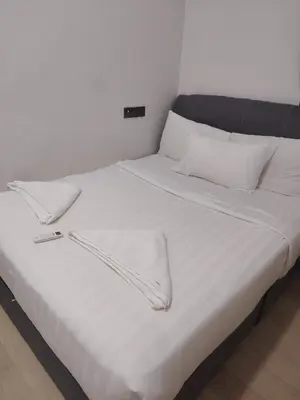 a white bed with white sheets and pillows at KL Suites At Star KLCC in Kuala Lumpur