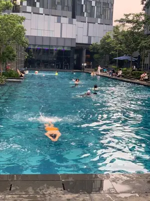 a group of people swimming in a swimming pool at KL Suites At Star KLCC in Kuala Lumpur