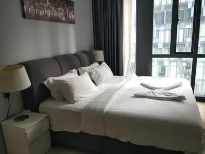 a bedroom with a large white bed with a window at KL Suites At Star KLCC in Kuala Lumpur