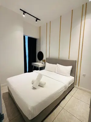 a bedroom with a bed with white sheets and a window at Luxury Residence At Axon in Kuala Lumpur
