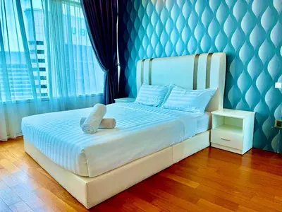 a bedroom with a white bed with a blue wall at Vortex klcc by DMK Luxury suites Apartment in Kuala Lumpur