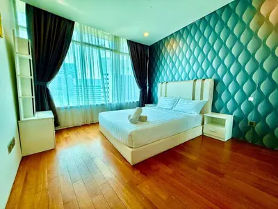 a bedroom with a bed with a blue wall at Vortex klcc by DMK Luxury suites Apartment in Kuala Lumpur