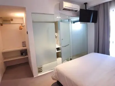 a bedroom with a white bed and a glass closet at Melange Boutique Hotel Bukit Bintang in Kuala Lumpur