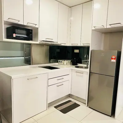 a kitchen with white cabinets and a stainless steel refrigerator at LuxeHive Stay in Kuala Lumpur