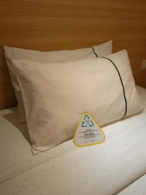 a warning sign sitting on a bed with a pillow at City Comfort Hotel Kuala Lumpur City Center (Bukit Bintang) in Kuala Lumpur