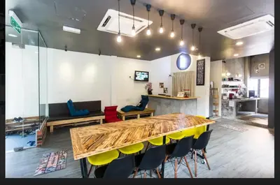 a room with a wooden table and chairs in it at Revopackers Beds and Bunks in Kuala Lumpur