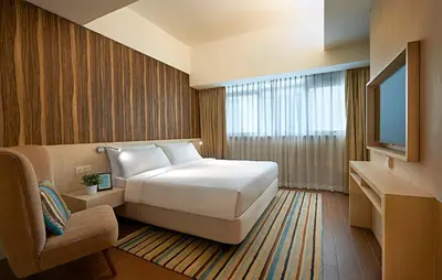 a hotel room with a bed and a television at Oasia Suites Kuala Lumpur by Far East Hospitality in Kuala Lumpur