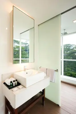a bathroom with a white sink and a mirror at Oasia Suites Kuala Lumpur by Far East Hospitality in Kuala Lumpur