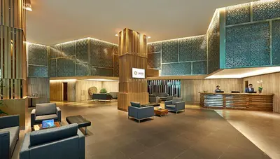 a lobby of a hotel with chairs and a bar at Oasia Suites Kuala Lumpur by Far East Hospitality in Kuala Lumpur
