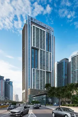 a tall building with cars parked in a parking lot at THE FACE Suites Hotel in Kuala Lumpur