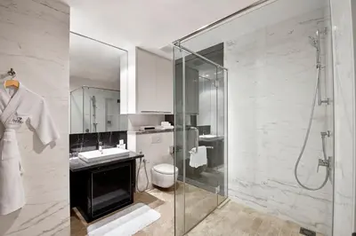 a bathroom with a shower and a sink and a toilet at THE FACE Suites Hotel in Kuala Lumpur