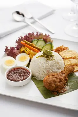 a plate of food with rice and meat and vegetables at THE FACE Suites Hotel in Kuala Lumpur
