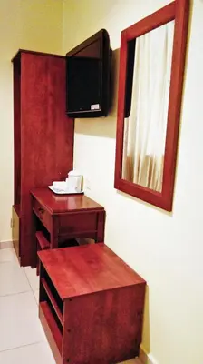 a bathroom with a mirror and a table and a tv at Sun Inns Hotel Sentral, Brickfields in Kuala Lumpur