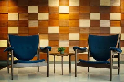 two chairs and a table in front of a wooden wall at Verdant Hill Hotel Kuala Lumpur in Kuala Lumpur
