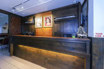 a bar in a restaurant with wooden walls at Hotel O Madras in Kuala Lumpur