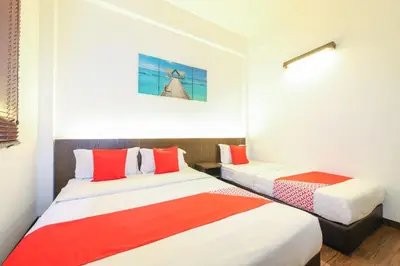 two beds in a room with red and white at Hotel O Madras in Kuala Lumpur