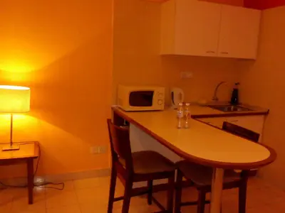 a kitchen with a table with chairs and a microwave at Richone Maluri Private Hotel in Kuala Lumpur