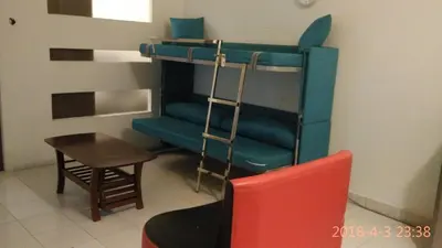 a room with a bunk bed with a chair and a table at Richone Maluri Private Hotel in Kuala Lumpur