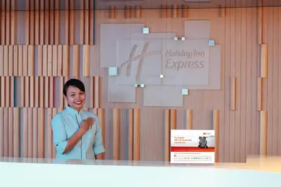 a woman standing in front of a wall with a sign at Holiday Inn Express Kuala Lumpur City Centre by IHG in Kuala Lumpur