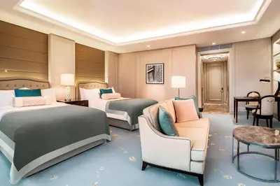 a hotel room with two beds and a couch at The St. Regis Kuala Lumpur in Kuala Lumpur