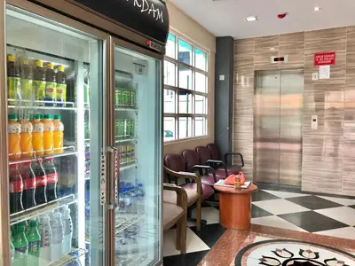 a waiting room with a refrigerator filled with drinks at Adamson Park Kuala Lumpur in Kuala Lumpur