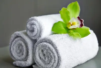 a stack of towels with a flower on top at VE Hotel & Residence in Kuala Lumpur