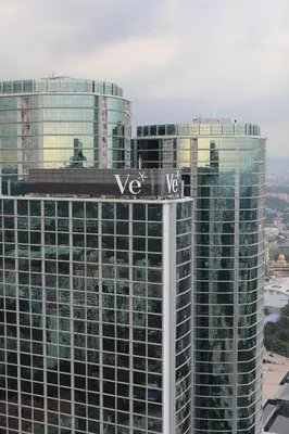 a view of two tall buildings with a street sign on top at VE Hotel & Residence in Kuala Lumpur