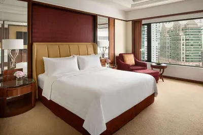 a hotel room with a large bed and a window at Shangri-La Kuala Lumpur in Kuala Lumpur