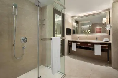 a bathroom with a glass shower and a sink at Shangri-La Kuala Lumpur in Kuala Lumpur