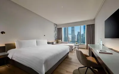 a hotel room with a large bed and a desk at Traders Hotel, Kuala Lumpur in Kuala Lumpur