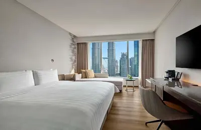 a hotel room with a large bed and a large window at Traders Hotel, Kuala Lumpur in Kuala Lumpur