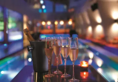 four champagne glasses sitting on a counter in a bar at Traders Hotel, Kuala Lumpur in Kuala Lumpur