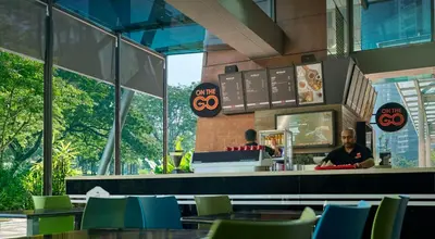 a man standing at the counter of a fast food restaurant at Traders Hotel, Kuala Lumpur in Kuala Lumpur